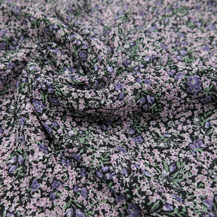 Fiori sparsi viola su sfondo nero